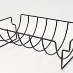 A black metal rack with multiple sections for roasting.