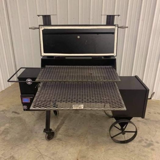 A grill that is sitting on top of the ground.
