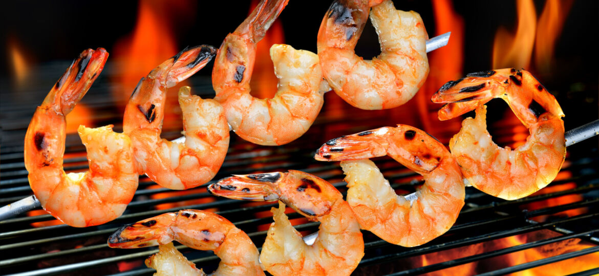 A grill with shrimp cooking on it.