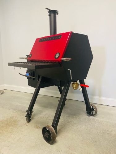 A red and black grill sitting on top of a floor.