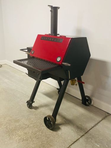 A red and black grill sitting on top of a floor.