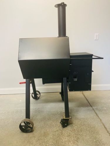 A black grill sitting on top of a cement floor.